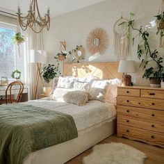 a bed room with a neatly made bed and lots of plants