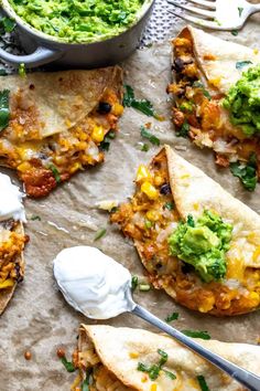 several tortilla shells with salsa, sour cream and guacamole