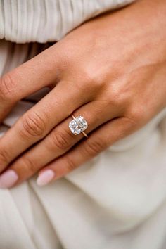 a woman's hand with a diamond ring on it