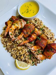 a plate with rice and shrimp on it next to a bowl of soup or sauce