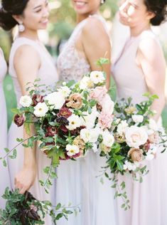 three bridesmaids holding bouquets in their hands