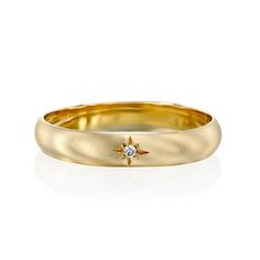 a yellow gold wedding band with a diamond in the center and a star on top