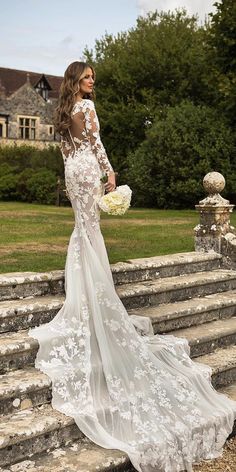 a woman in a wedding dress standing on some steps