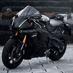 a black motorcycle parked on top of a sidewalk