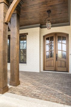 the front entrance to a house with wooden doors