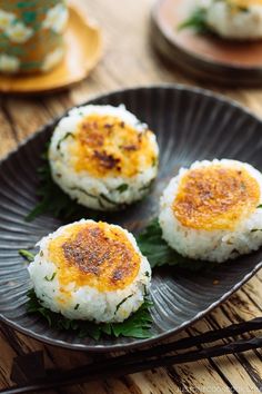 three pieces of rice on a plate with chopsticks