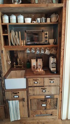 a kitchen area with wooden cabinets and white dishes