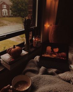 a cup of coffee sitting on top of a window sill next to a book