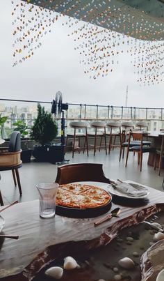 a pizza sitting on top of a wooden table next to a glass filled with water