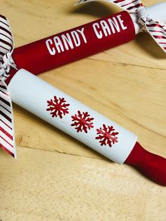 two candy canes decorated with red and white snowflakes are sitting on a table