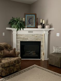 a living room with a couch, chair and fire place in front of a fireplace