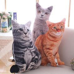 three cats sitting on top of a white couch