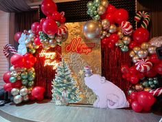 a stage set up with balloons and decorations for a christmas themed party, including a polar bear