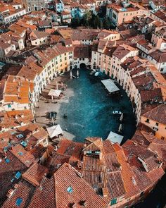 an aerial view of a city with lots of red roofs and brown tile on the buildings