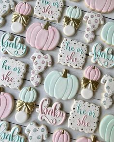 baby shower cookies decorated with pastel colors and gold bows are displayed on a table