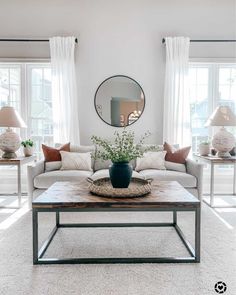 a living room filled with furniture and a large mirror on the wall above it's coffee table