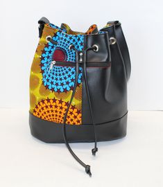 This is a great casual bucket bag made with marine vinyl and beautiful African Print Fabric. It can be worn as a crossbody bag or as a shoulder bag. Measurement: 13 inches height x 14 inches wide x 11 x 6 inches wide oval bottom Features 1 Zipper pocket on the outside of the bag 2 Slip Pockets inside 1 Zipper pocket inside Adjustable straps Please contact me if you have any questions about this bag. This bag is made to order and the lining ( inside) will be black. Please visit my shop at: http:/ School Satchel With Detachable Strap And Bucket Shape, Multicolor Bucket Shoulder Bag With Adjustable Strap, Trendy Multicolor Bucket Bag, School Bucket Bag With Detachable Strap, School Bucket Hobo Bag, Multicolor Bucket Bag With Removable Pouch As Gift, Multicolor Bucket Bag With Removable Pouch, Multicolor Shoulder Bucket Bag With Removable Pouch, Multicolor Bucket Satchel With Adjustable Strap