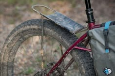 a close up of a bike with a bag on the front wheel and back tire