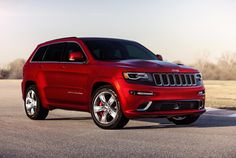 a red jeep parked on the side of a road