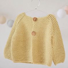 a yellow sweater hanging on a clothes rack