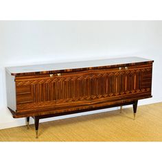 a large wooden cabinet sitting on top of a hard wood floor next to a white wall