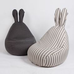 two bean bags sitting next to each other on top of a white floor covered in grey and white stripes