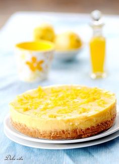 a cheesecake on a white plate with lemons in the backgroung