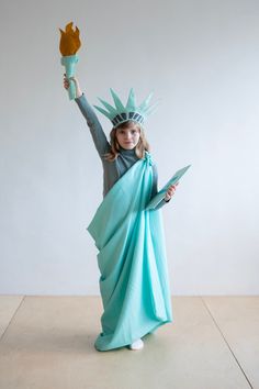 Celebrate in style with our charming Handmade Felt Statue of Liberty Costume for kids!  providing a unique and fun way to embrace the spirit of freedom, Includes a beautifully draped Roman cloth robe tied over the shoulder, a crown with iconic spikes, a torch to symbolize freedom and a plaque bearing the inscription JULY IV MDCCLXXVI Crafted from soft, durable felt for comfort and longevity. Designed for simplicity, making it easy for kids to put on and take off. This delightful costume is Ideal Kindergarten Halloween Costumes, Diy Statue Of Liberty Costume, Desert Costume, Lumiere Costume, Greek Mythology Costumes, Statue Of Liberty Costume, Mythology Costumes, Wardrobe Costume, Statue Of Liberty Crown