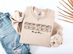 a shirt that says senior on it next to some denim shorts and a pair of shoes