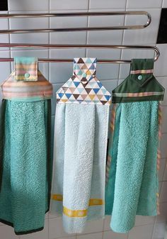 three towels hanging on a rack in a bathroom