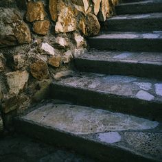 stone steps leading up to a wall made of rocks