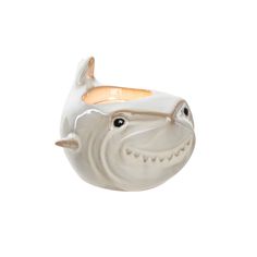 a white ceramic fish with gold accents on it's face and mouth, sitting in front of a white background