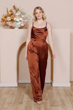 An exciting take on the classic bridesmaid dress, the Parker Satin Jumpsuit's universally flattering silhouette will have everyone in your bridal party deciding on this alternative to wearing a dress! Parker is styled after our best-selling Skye Satin dress with a modest cowl neckline and a fitted waistline that flows into delicate flowing pants. FEATURES: Fitted silhouette Cowl neckline Built-in bra cups and vertical boning for support Adjustable satin spaghetti straps Back zipper Full-length s Sheath Bridesmaid Dress, Classic Bridesmaids Dresses, Flowing Pants, Brown Bridesmaid Dresses, Wedding Parties Colors, Satin Jumpsuit, Bridesmaid Dress Colors, Sparkle Dress, Cowl Neckline