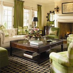 a living room with couches, chairs and a coffee table in front of a fire place