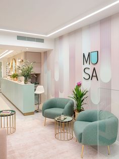 an office lobby with chairs and tables in front of a wall that says mom sa