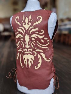 Greenman Deerskin Leather Vest Beautiful, soft, medium weight buckskin leather vest. Featuring an intricate cutout design of a Green Man.  Let us make one just for you! This listing is for the Greenman in 1 contrasting color, we can also make this design more intricate with a combination of colors. Tell us your dreams for this badass piece! The Green Man is a legendary being primarily interpreted as a symbol of rebirth, representing the cycle of new growth that occurs every spring. He is a form Leather Sleeveless Vest For Festivals, God Osiris, Renn Faire, Horned God, Leather Choker Collars, The Green Man, Divine Masculine, Green Knight, Leather Leaf