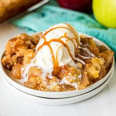 an apple crisp with ice cream and caramel drizzle on top in a white bowl