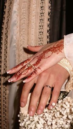 the bride and groom are holding their hands with henna tattoos on it's arms