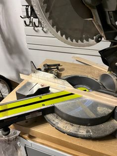 a circular saw sits on top of a table next to a pair of scissors and a piece of wood