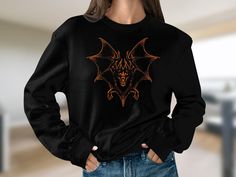 Embrace the Halloween spirit with our Vintage 90s Style Bat Sweatshirt--where retro meets spooky in perfect harmony. This Y2K-inspired unisex shirt is not just a seasonal piece; it's a timeless expression of your unique style and love for all things dark and mystical. Crafted from a cozy and soft fabric blend, this sweatshirt ensures you stay warm while making a fashion statement. The dark, spooky bat design adds a touch of gothic charm, perfect for Halloween parties, casual outings, or cozy nig Y2k Cotton Sweatshirt For Halloween, Y2k Halloween Graphic Print Sweatshirt, Y2k Graphic Print Halloween Sweatshirt, Y2k Graphic Print Sweatshirt For Halloween, Alternative Halloween Crew Neck Top, Alternative Crew Neck Halloween Tops, Halloween Concert Long Sleeve Tops, Long Sleeve Halloween Concert T-shirt, Long Sleeve Tops For Halloween Concert