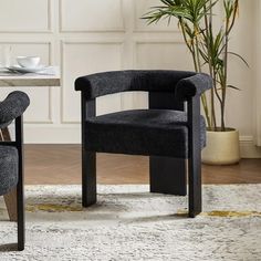 two chairs sitting on top of a rug next to a table with a potted plant