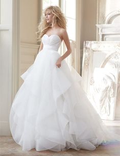 a woman in a white wedding dress posing for the camera