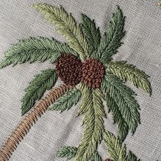 an embroidered palm tree with red berries and green leaves