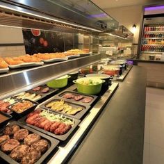 an assortment of food is on display in a deli or restaurant counter top area