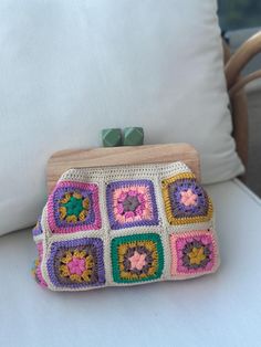 Handcrafted with creamy based and colorful yarns. it made with high quality %100 cotton yarns. Its sturdy kiss lock keeps your essentials secure.  You can combine it with various outfits. You can use in four seasons.  And it comes with removable brown, slender leather straps. Wear it crossbody, on your shoulder or simply remove the strap and carry it by hand as a clutch .  The clasp is made of wood. it designed with love for you 🌸  📍 It will sent you in a gift package . 📍adjustable bag strap 📍Lined and wooden frame with buckle closure Please feel free yourself to contact with me for any other informations or requests about your order. Please not that buyers are responsible for any customs and import taxes that may apply. I'm not responsible for delays due to customs. Thank you for visi Handmade Square Crochet Bag For Spring, Beige Crochet Rectangular Clutch, Handmade Multicolor Crochet Clutch Bag, Handmade Square Clutch For Daily Use, Rectangular Crochet Clutch For Daily Use, Everyday Use Crochet Rectangular Clutch, Spring Crochet Bag With Granny Square For Daily Use, Spring Square Crochet Bag With Granny Square Details, Spring Granny Square Crochet Bag