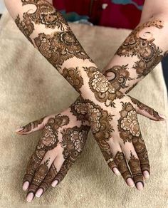 two hands with henna tattoos on them