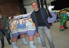 a man standing next to a statue of a horse with cartoon characters painted on it