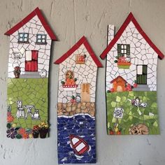 three small houses are hanging on the wall