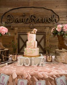 a table topped with a pink and white cake