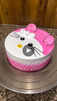 a hello kitty cake with pink icing on a silver plate